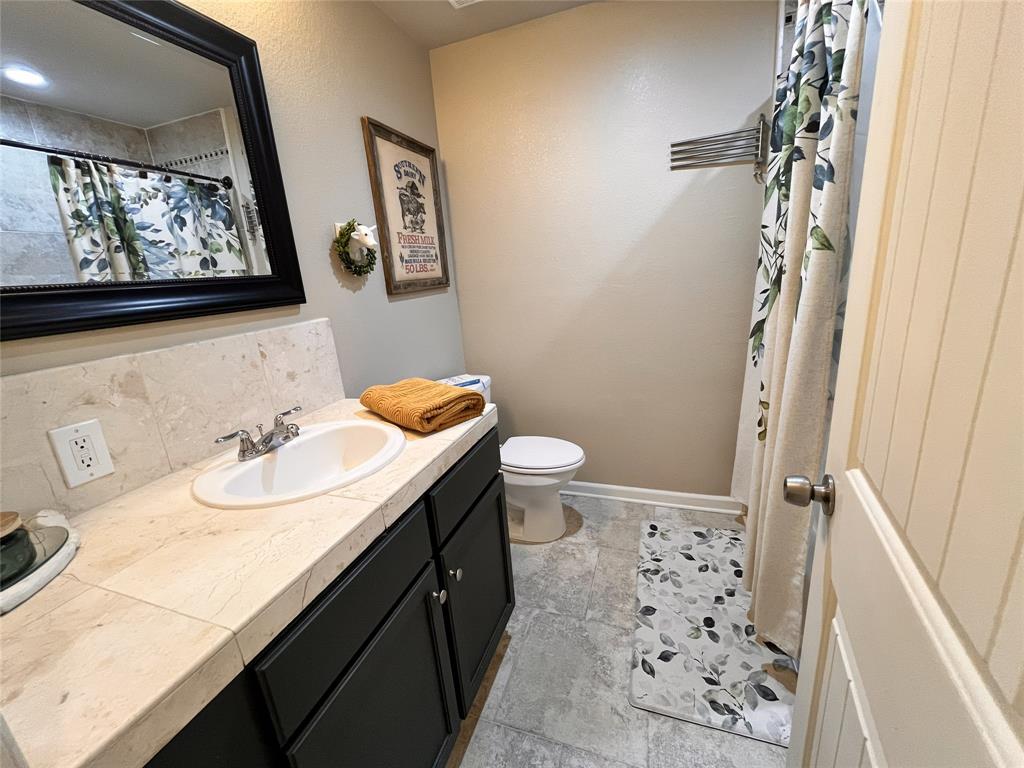 420 Sessums Road Springtown, TX 76082 - Photo 28 of 40 Full bathroom with vanity, a shower, and decorative backsplash