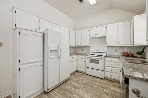 a kitchen with white cabinets and white appliances