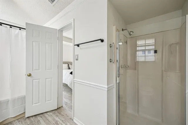a bathroom with a shower and a glass door