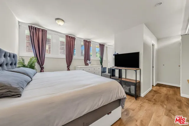 a bedroom with a bed and a flat screen tv