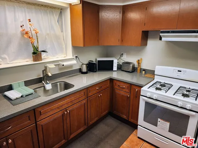 a kitchen with stainless steel appliances granite countertop a sink stove and cabinets