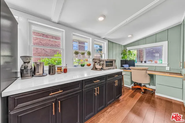 a kitchen with stainless steel appliances a sink stove and wooden floor
