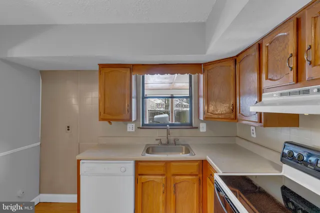 a kitchen with stainless steel appliances a sink stove and cabinets