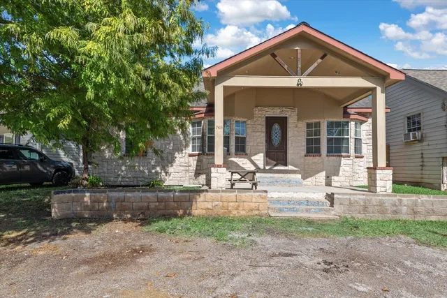 a view of a house with backyard and trees