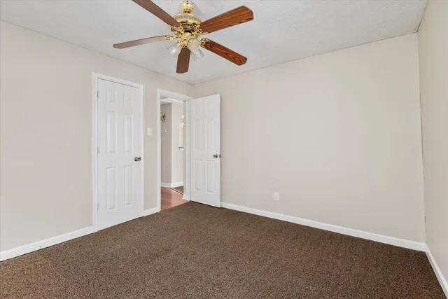 an empty room with a ceiling fan and a window