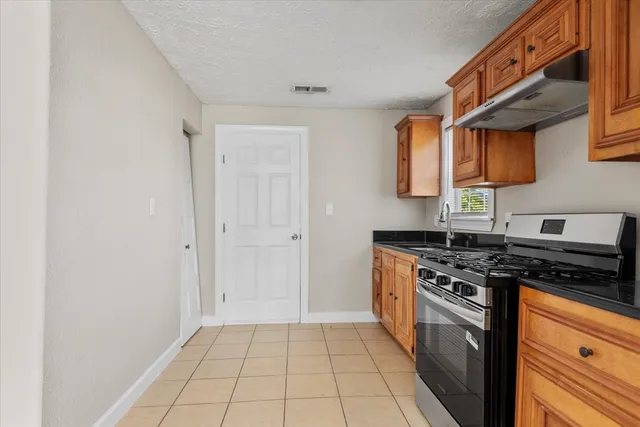 a kitchen with a stove top oven and cabinets