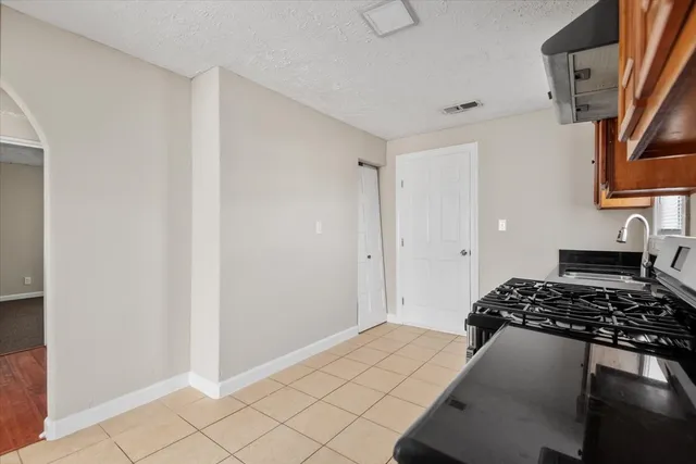 a bedroom with a bed and a lamp on the dresser