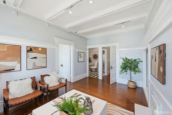 a living room with furniture potted plant and wooden floor