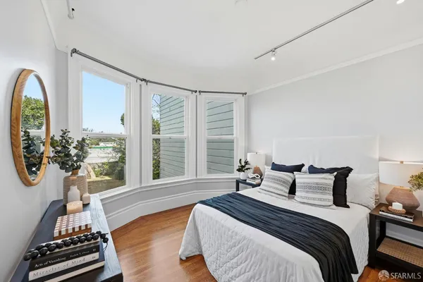 a bedroom with furniture and a large window