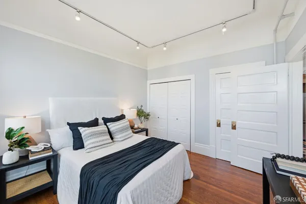 a bedroom with a bed and wooden floor