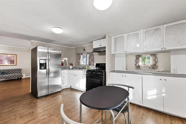 a kitchen with granite countertop a refrigerator stove top oven and sink