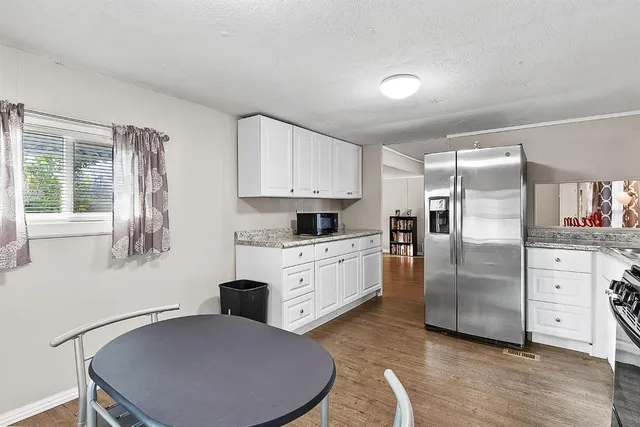 a kitchen with stainless steel appliances granite countertop a refrigerator a stove and a sink