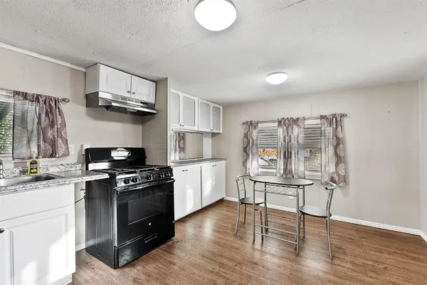 a kitchen with refrigerator cabinets and wooden floor