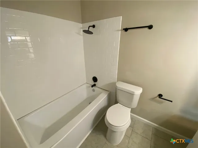 a white toilet sitting next to a bath tub