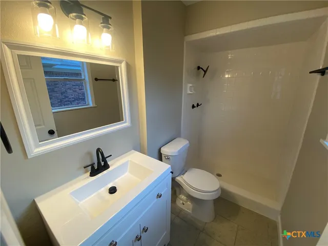 a bathroom with a sink a toilet and a mirror