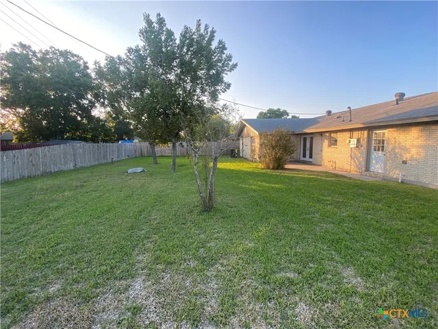 a view of a field of grass and trees