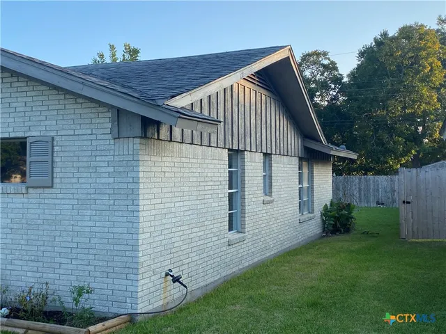 a view of backyard of house with green space