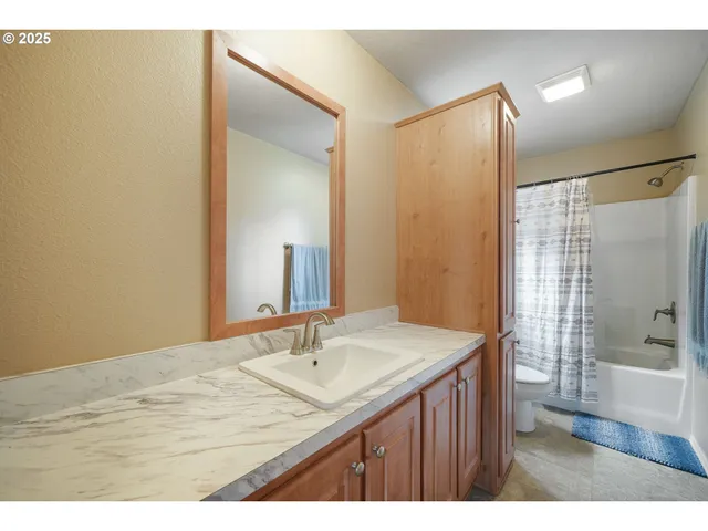 a bathroom with a sink shower and a mirror