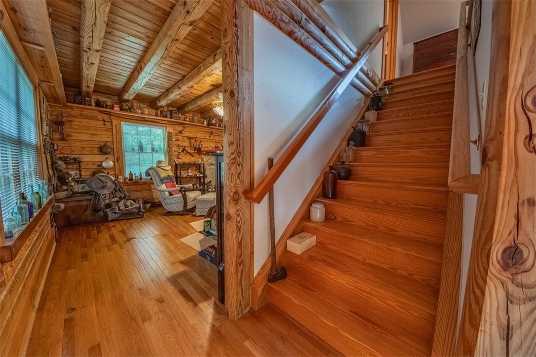 846 Twiggs Ferry Road Hartfield, VA 23071 - Photo 23 of 28 Stairway featuring hardwood / wood-style flooring, wood walls, and a wood ceiling with exposed beams