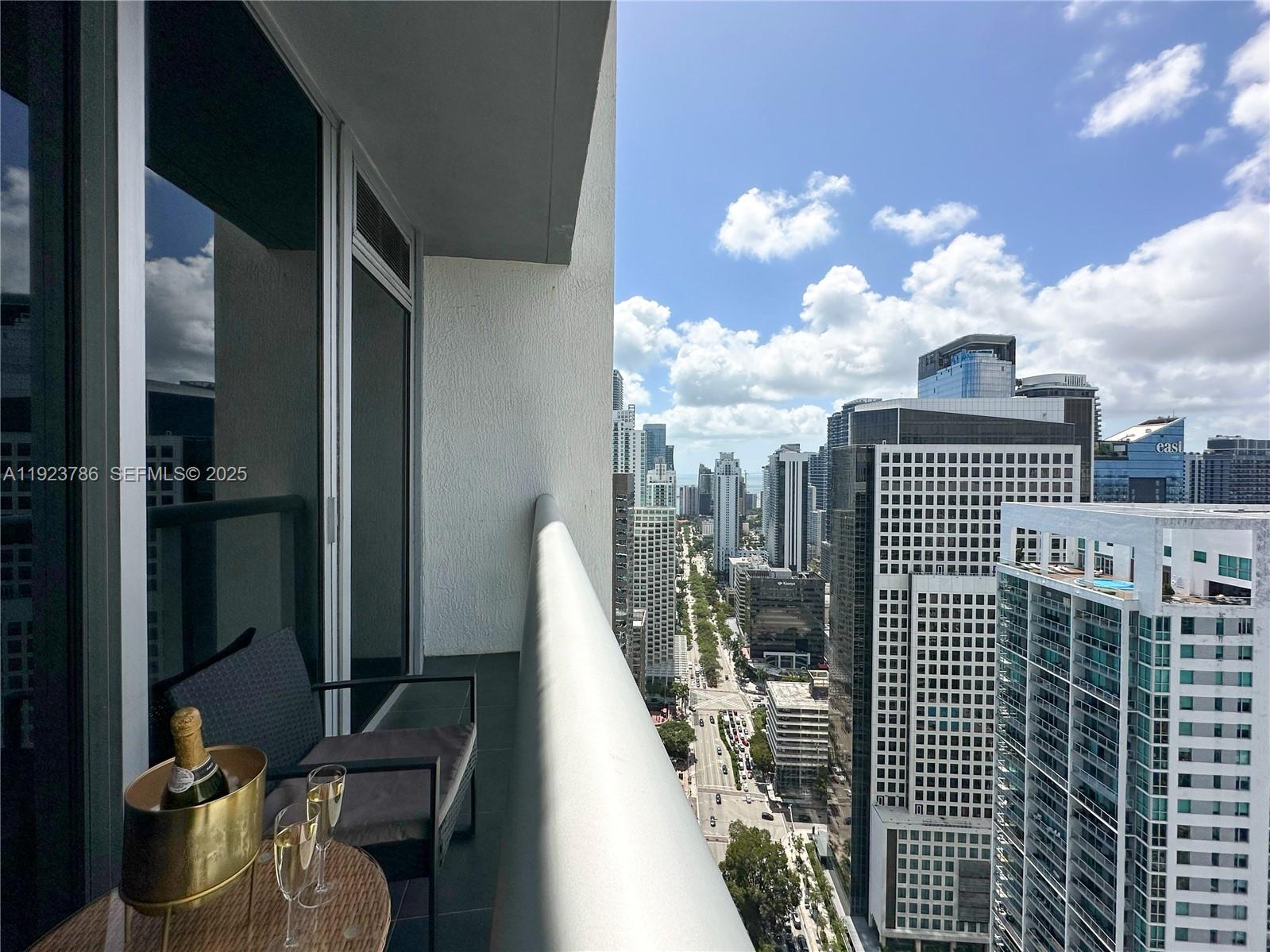 485 Brickell Avenue, Unit 4405 Miami, FL 33131 - Photo 6 of 19 a view of a balcony with dining table and chairs