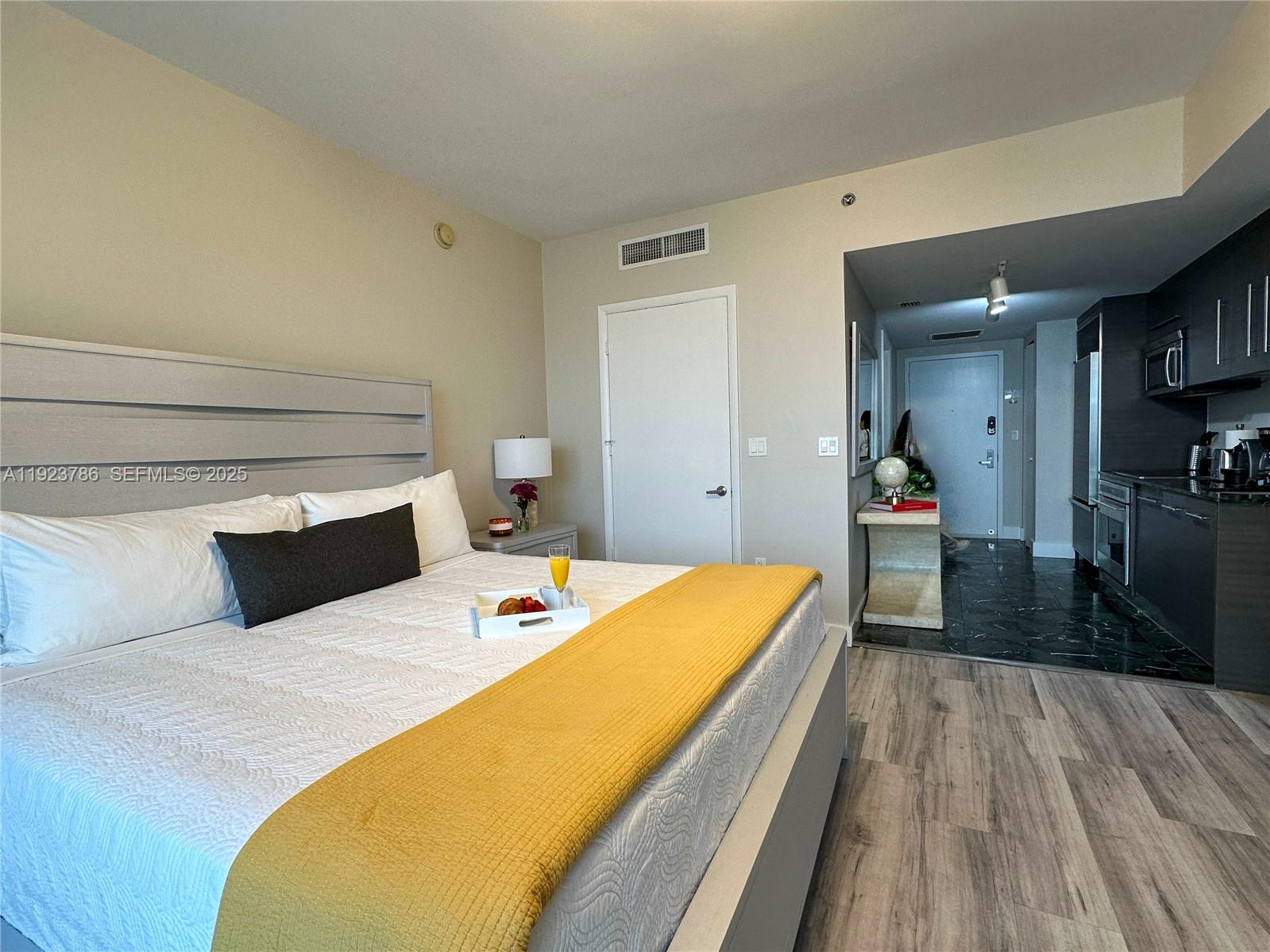 485 Brickell Avenue, Unit 4405 Miami, FL 33131 - Photo 7 of 19 a bed sitting in a bedroom and view of kitchen