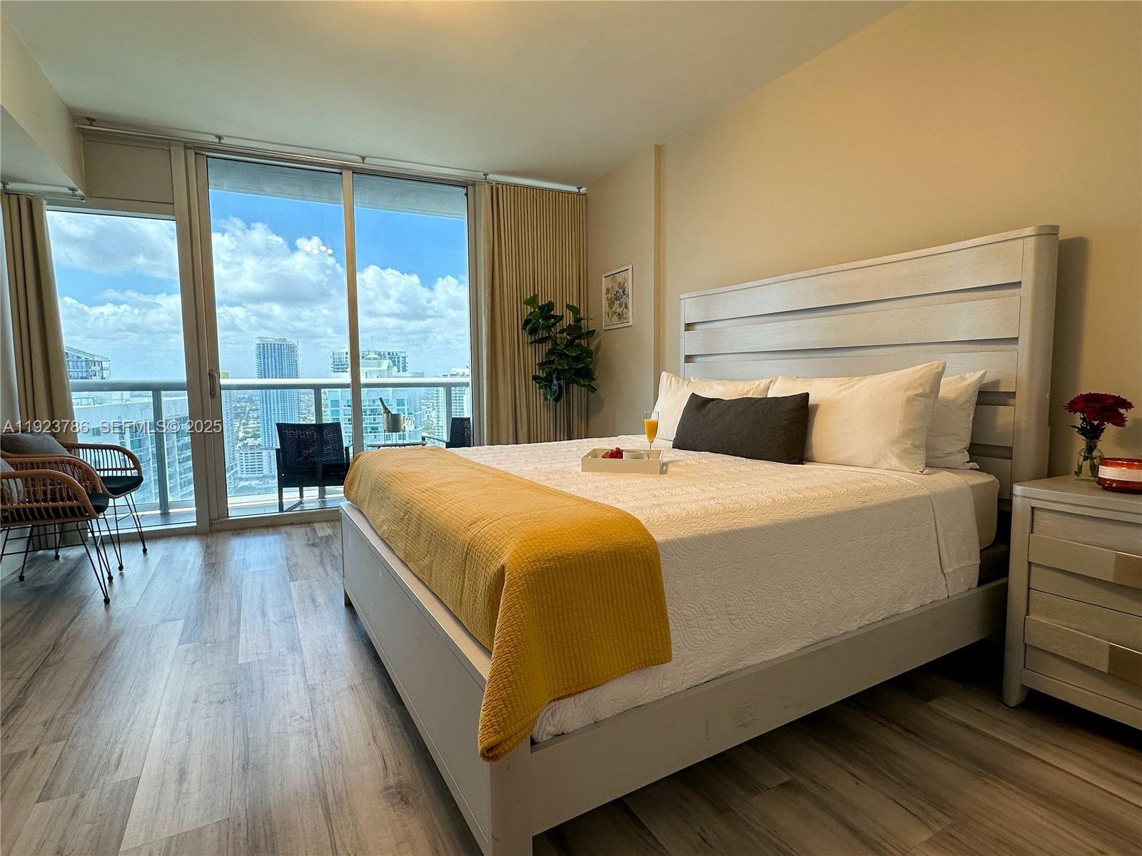 485 Brickell Avenue, Unit 4405 Miami, FL 33131 - Photo 8 of 19 a bedroom with a bed and wooden floor