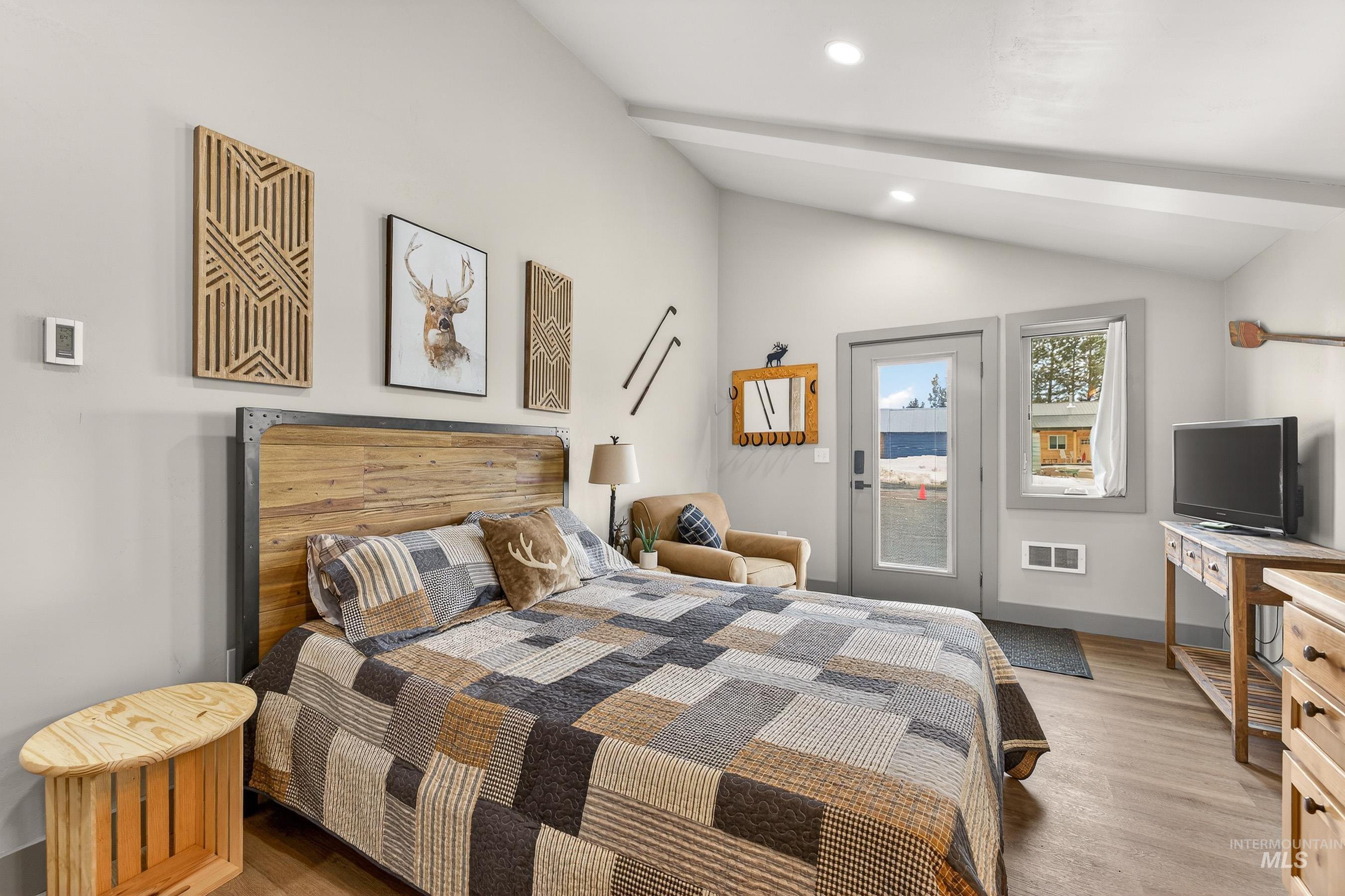 304 Samson Court, Unit 656 McCall, ID 83638 - Photo 20 of 29 Bedroom featuring access to exterior, light wood-type flooring, lofted ceiling with beams, and recessed lighting