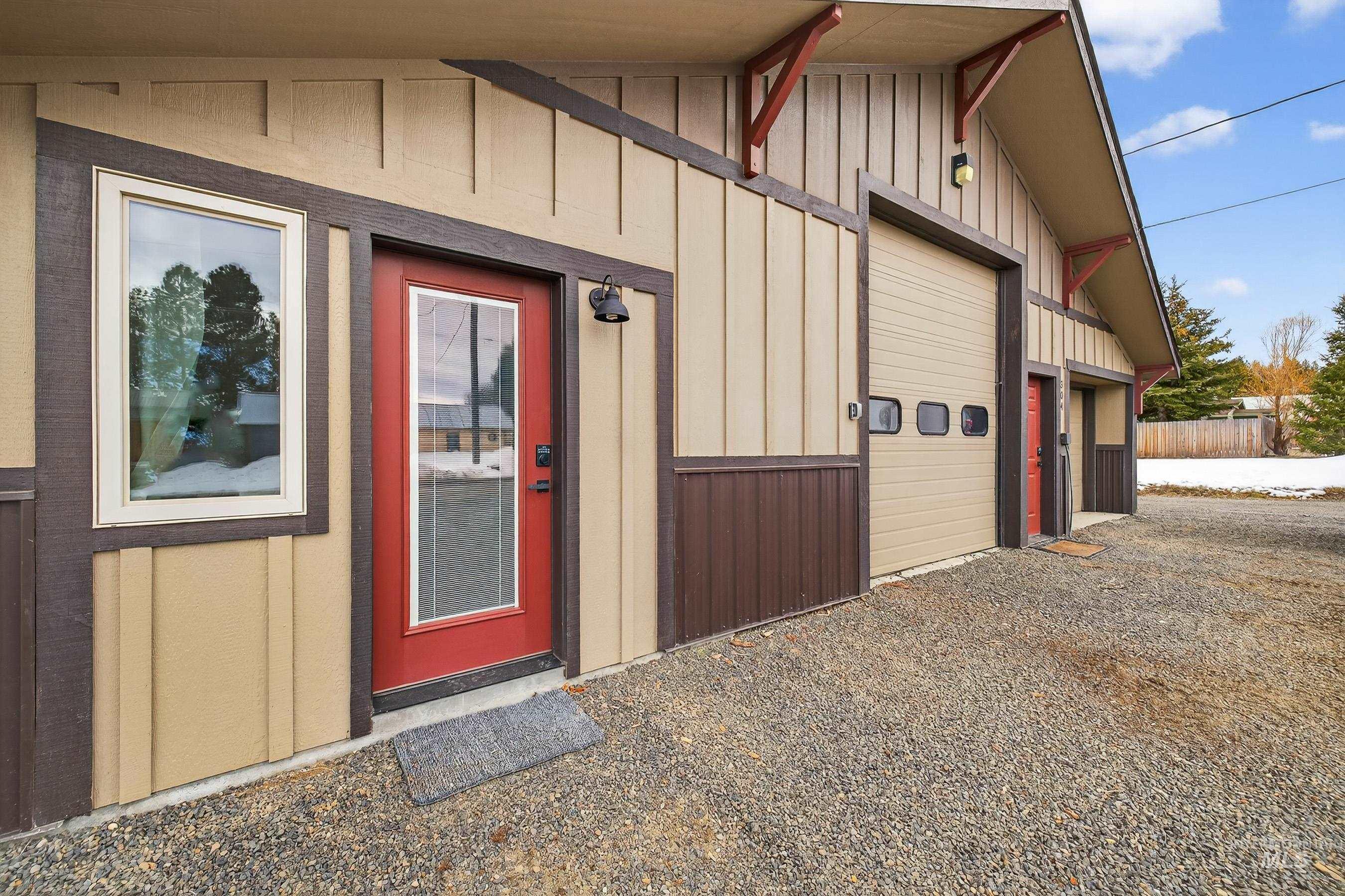 304 Samson Court, Unit 656 McCall, ID 83638 - Photo 27 of 29 Doorway to property with board and batten siding, a garage, and driveway