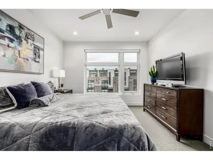 a bedroom with a large bed and a flat tv screen on dresser