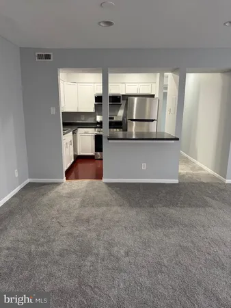 a kitchen with a sink a refrigerator and cabinets