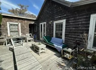 a view of a patio with table and chairs with wooden floor and fence