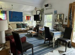 263 E Walk Ocean Beach, NY 11770 - Photo 2 of 6 a living room with furniture wooden floor and a flat screen tv