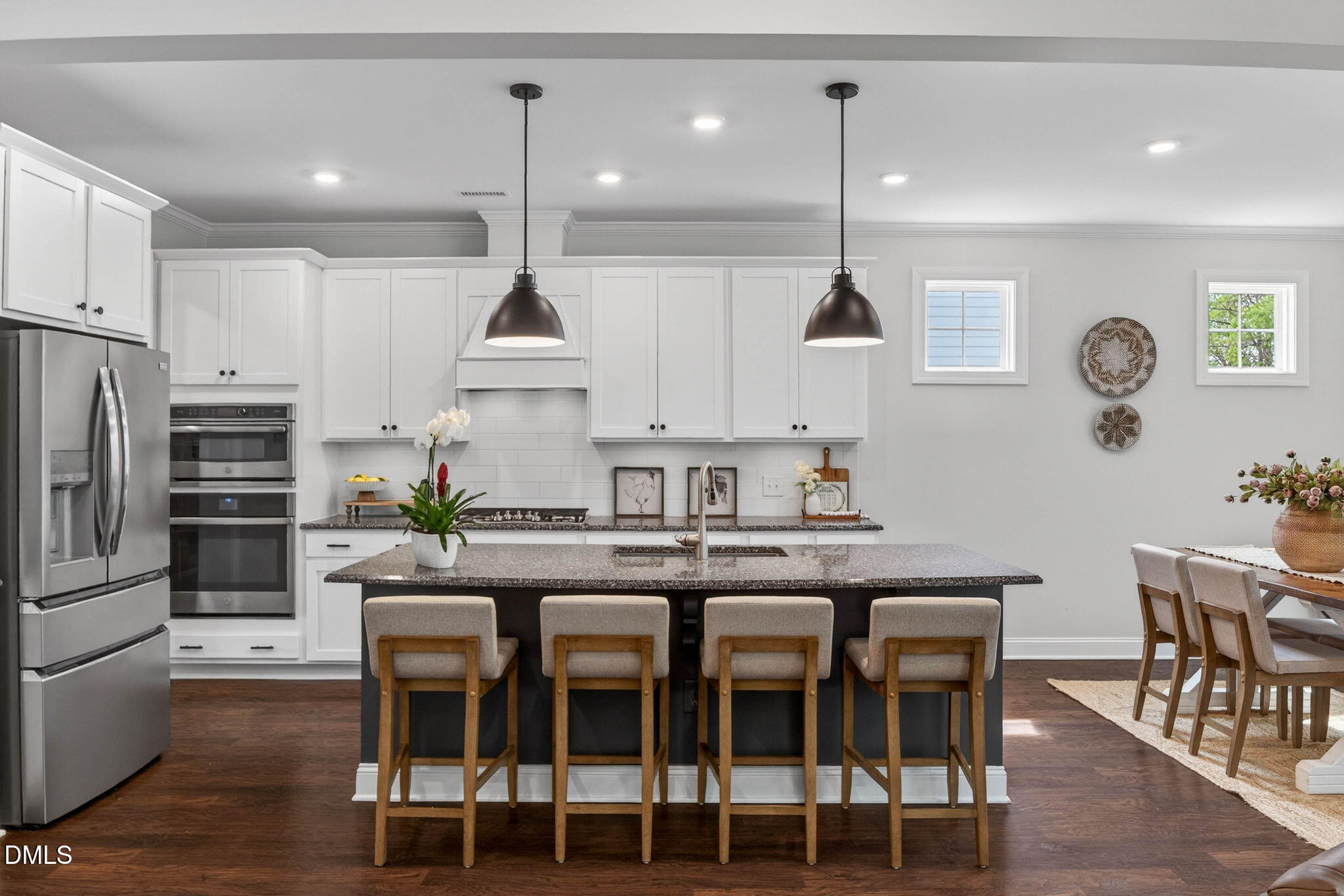 721 Hydrangea Field Court Wake Forest, NC 27587 - Photo 22 of 71 a kitchen with stainless steel appliances granite countertop a dining table chairs stove and white cabinets