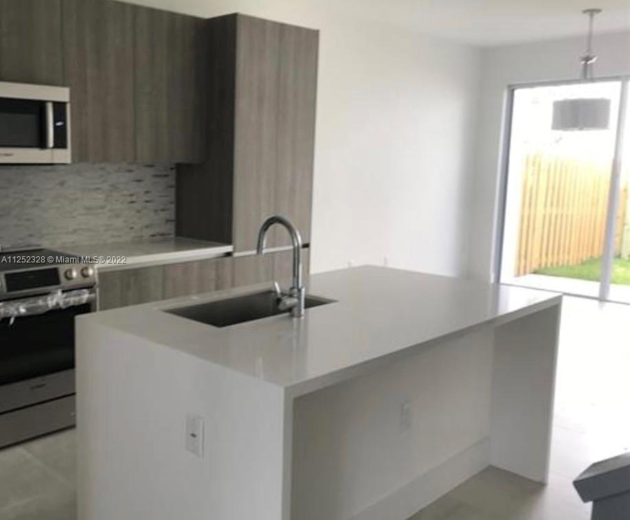 7261 Northwest 103rd Path Doral, FL 33178 - Photo 5 of 10 a kitchen with a sink and a refrigerator