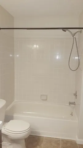 a white toilet sitting next to a bath tub