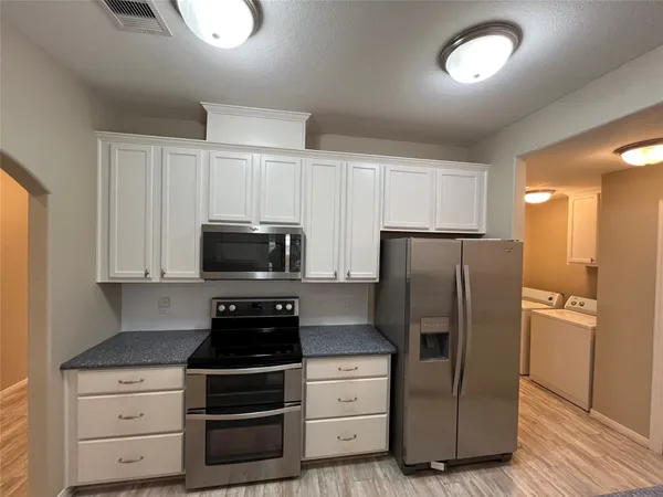 a kitchen with a refrigerator stove and cabinets