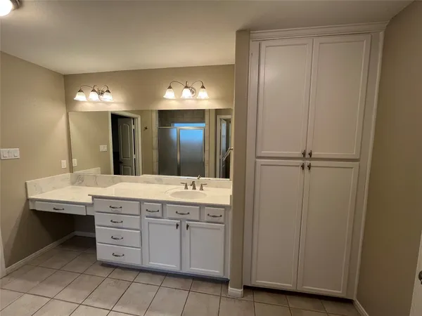 a bathroom with a granite countertop sink a mirror and a vanity