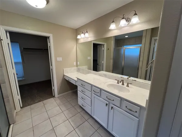 a spacious bathroom with a double vanity sink and a mirror