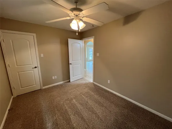an empty room with closet and a chandelier fan