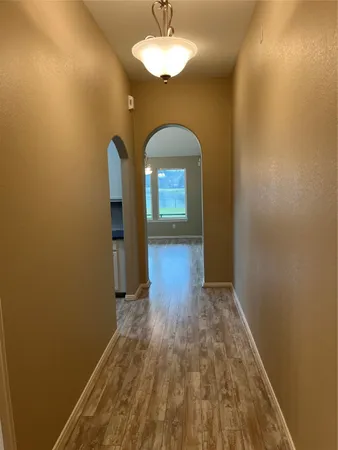 a view of a room with wooden floor and a mirror