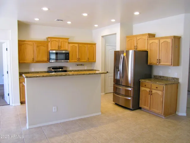 a kitchen with stainless steel appliances granite countertop a refrigerator a stove a sink and a refrigerator