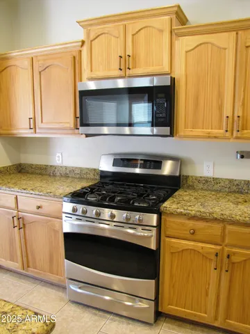a kitchen with granite countertop a stove and a microwave