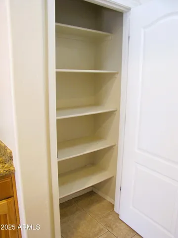 a view of walk in closet with empty racks