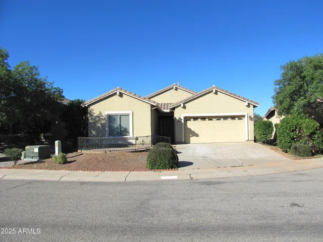 a view of a house with a yard and large tree
