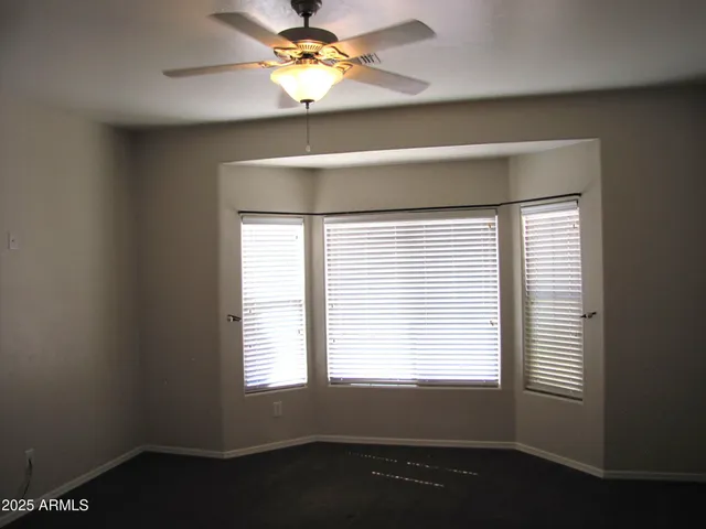 an empty room with a window and a fan