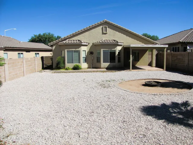 a front view of a house with a dirt yard and a window