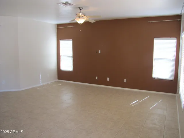 an empty room with windows and fan