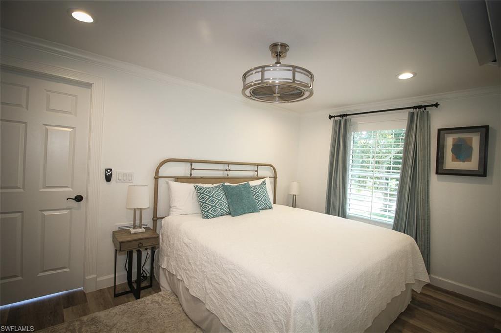 1645 Mullet Court Naples, FL 34102 - Photo 12 of 38 a bedroom with a large bed and a chandelier
