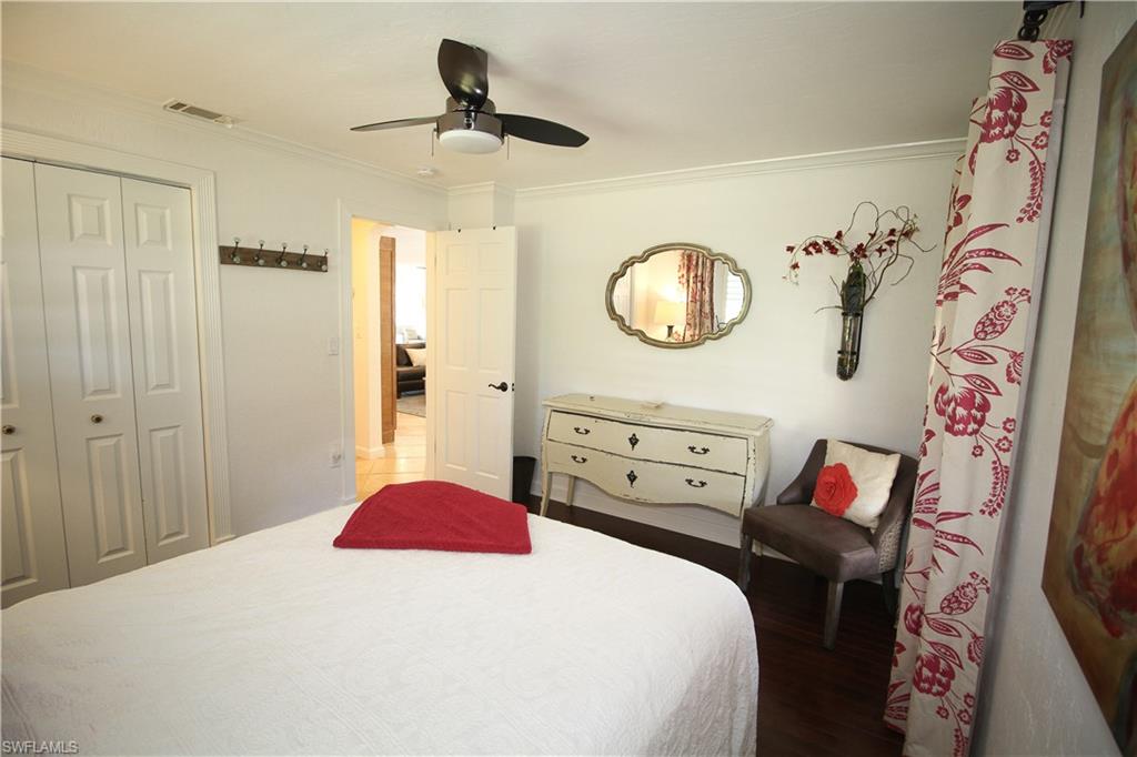 1645 Mullet Court Naples, FL 34102 - Photo 27 of 38 a bedroom with a bed and a chandelier