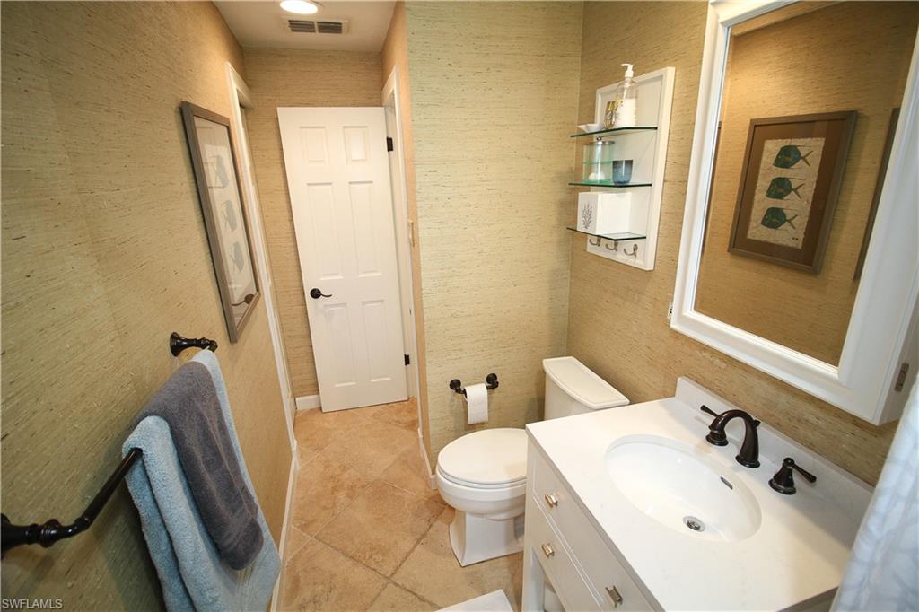 1645 Mullet Court Naples, FL 34102 - Photo 29 of 38 a bathroom with a sink mirror vanity and toilet